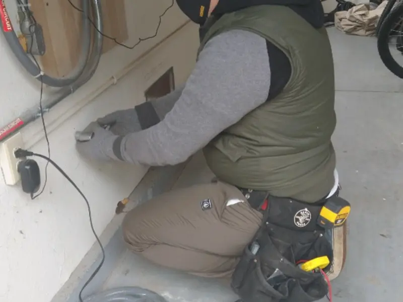 Electrician performing outlet wiring in a Suffield garage